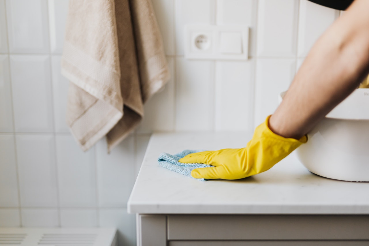 personne qui nettoie le lavabo d'une salle de bain