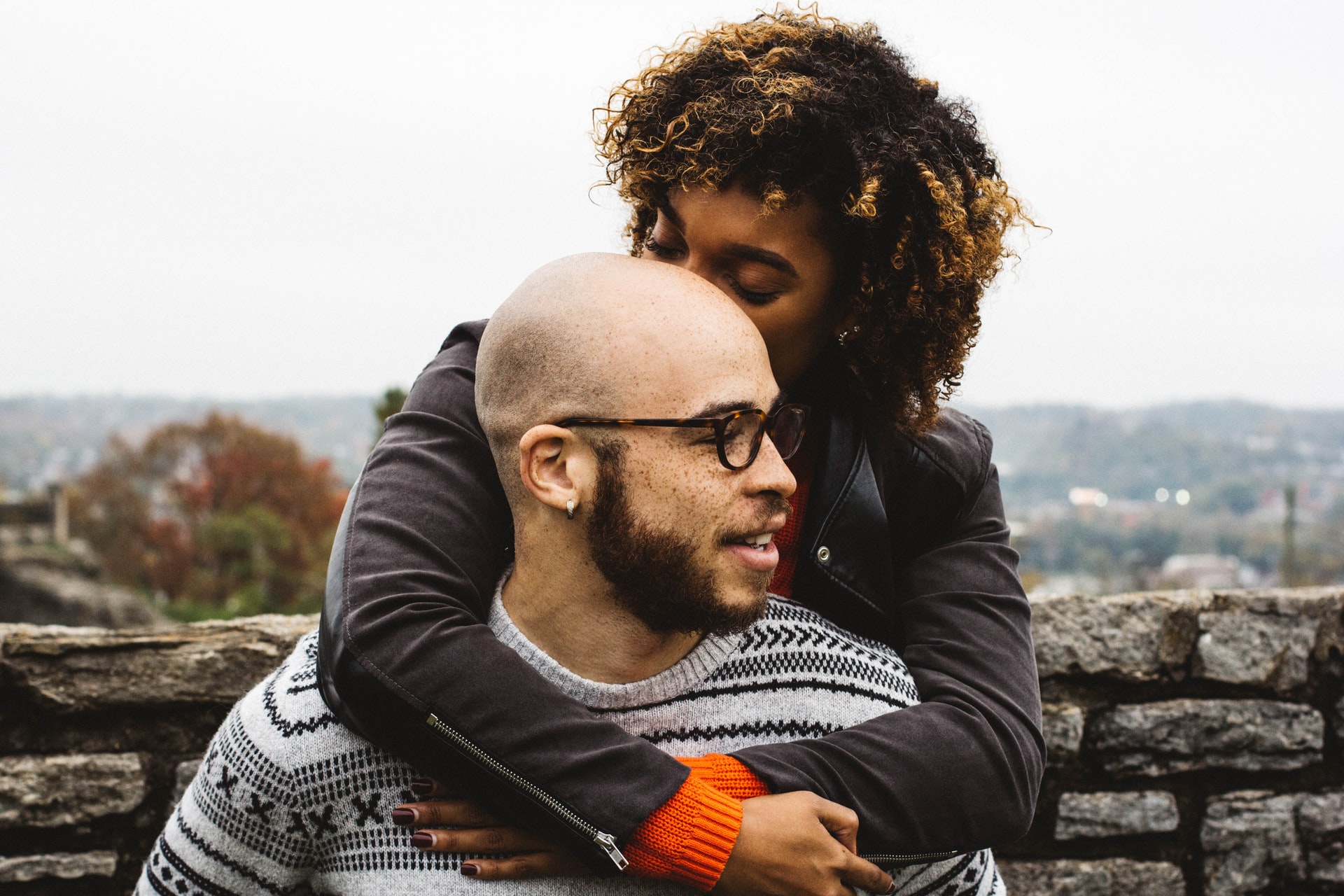 homme chauve avec une femme qui embrasse son crâne